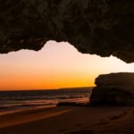 silhouette of rocky mountain on seashore